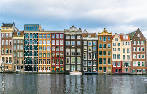 Photography A row of old traditional houses at the Damrak in Amsterdam