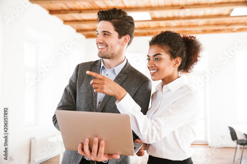 Smiling multhiethnic business couple working photo