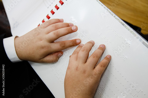 Hand reading the Braille text photo