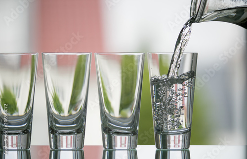 pure,natural freshwater, being poured into a classical trinking glass photo