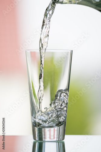 pure,natural freshwater, being poured into a classical trinking glass