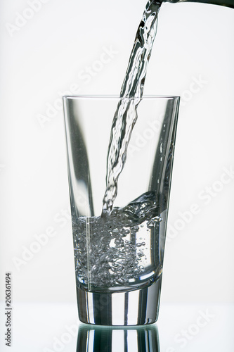 pure,natural freshwater, being poured into a classical trinking glass photo