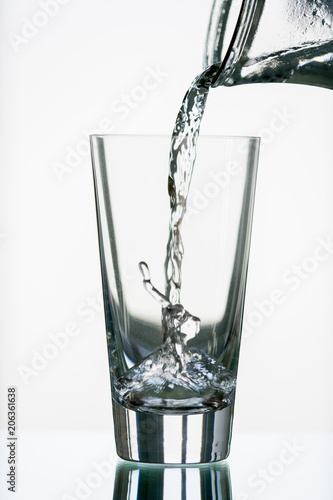 pure,natural freshwater, being poured into a classical trinking glass photo