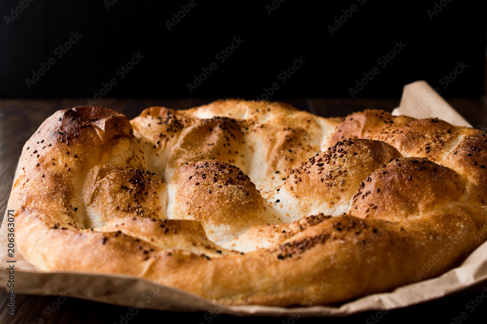 Turkish Ramadan Bread - Ramazan Pidesi on wooden surface / Pide Turkish Ramadan Bread - Ramazan Pidesi on wooden surface / Pide