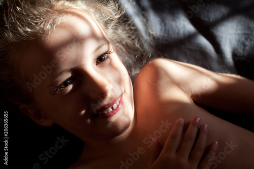 Face in sunlight. Close up portrait of a beautiful girl, half face in a shadow