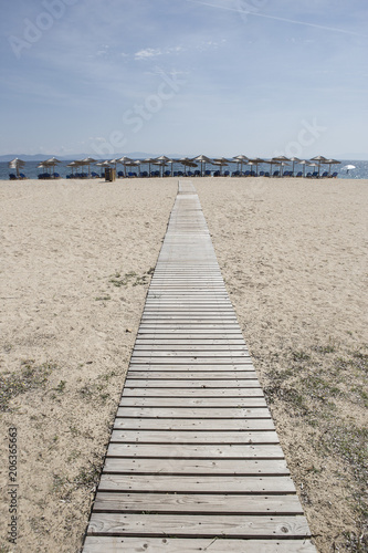wooden boards ,walkway for beutiful sand beach with sun-beds