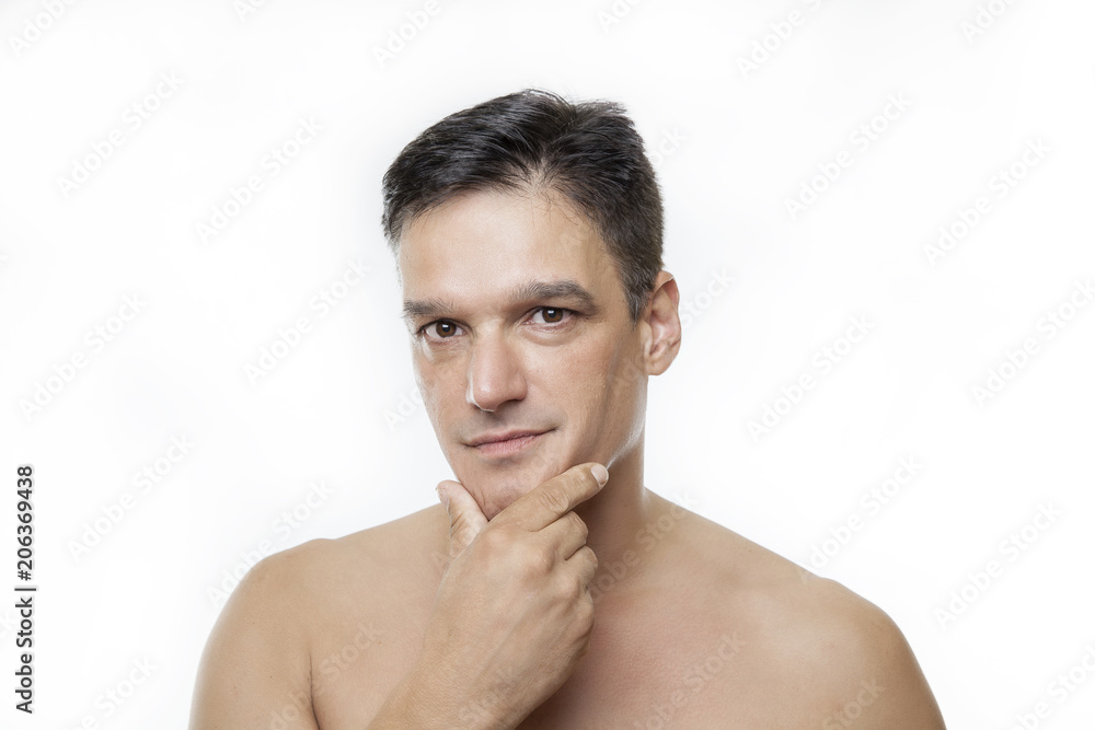 Obraz premium Shirtless young man with hand to chin against white background