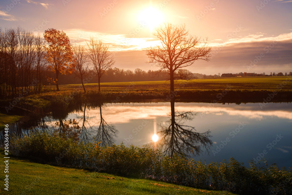 Fototapeta premium field with lake on sunset in Latvia on cloudy sky background