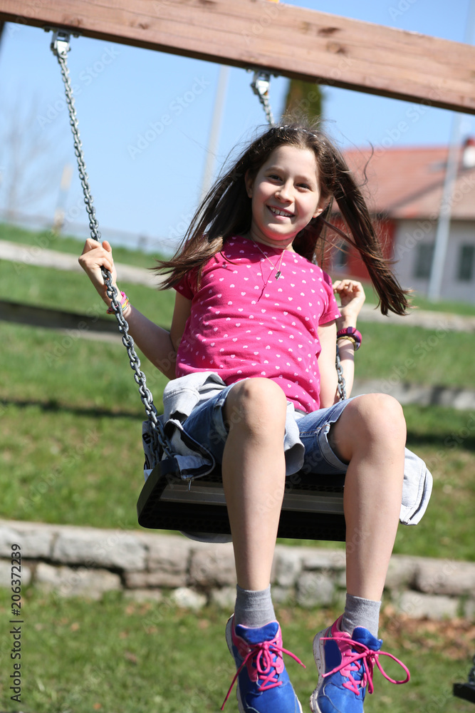 little girl has fun on the swing