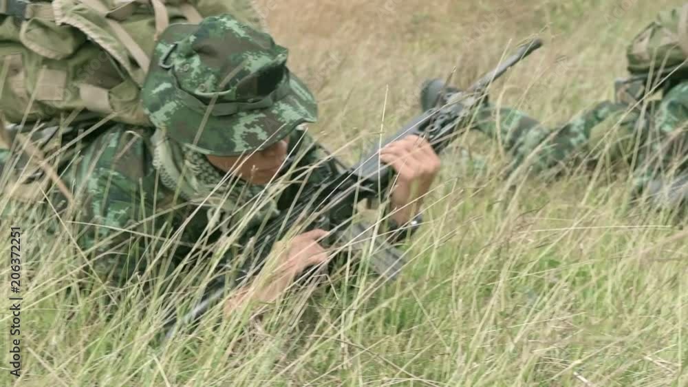 Slow motion of soldier crawling on grass field. Two chinese special force soldiers crawling together on the grass land toward camera. Slow motion of soldier crawling on grass field. Two chinese special force soldiers crawling together on the grass land toward camera.
