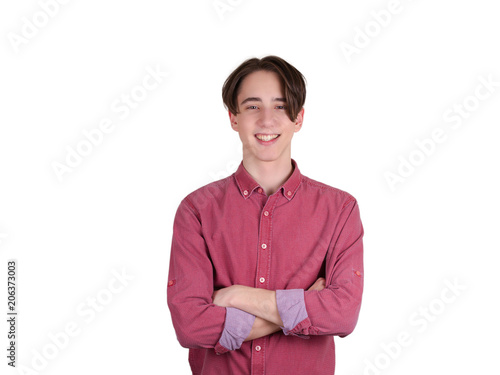 Handsome teen boy looking at camera. Portrait of teenager in shirt. Confident young man keeping arms crossed and smiling, isolated on white background
