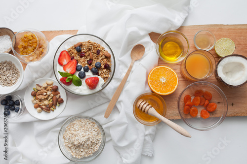 Ingredients for a healthy breakfast - granola  honey  nuts  berries  fruits  top view.