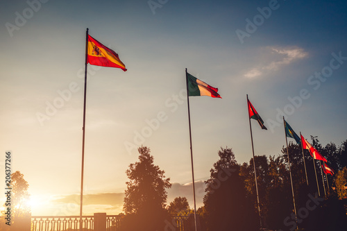 A row of flying flags of nations on sunset sky background. Flags of different countries