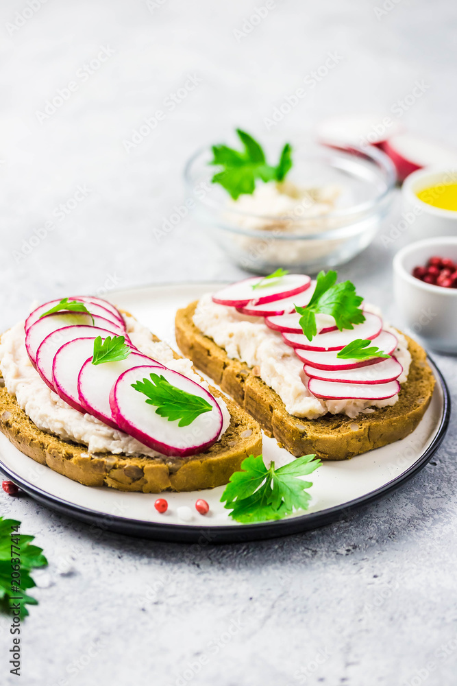 white bean hummus radish sandwiches on concrete background. Selective focus, space for text. white bean hummus radish sandwiches on concrete background. Selective focus, space for text.
