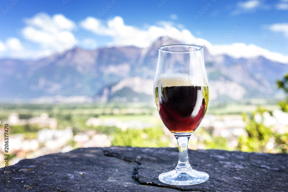 A glass of fresh beer on the background of the mountains