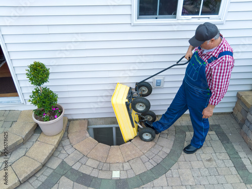 Man performing maintenance on an egress window