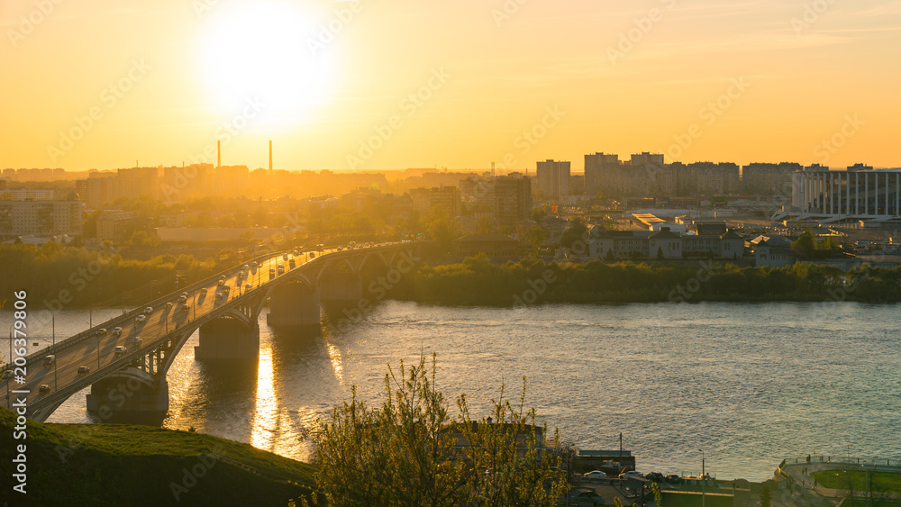 View from the high on Nizhny Novgorod city in Russia, Kanavinsky Bridge over the Oka River at sunset, moving cars on the road