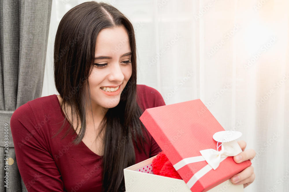Happy pretty young woman holding gift box in the house Happy pretty young woman holding gift box in the house
