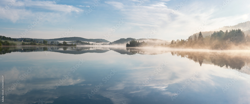 French landscape - Jura. View over the lake of Ilay in the Jura mountains (France) at sunrise with mist.