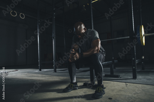 Male athlete relaxing in gym photo