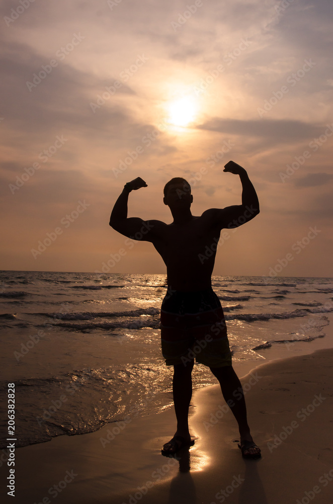 Silhouette of a muscular man on the beach
