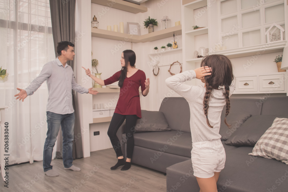 Fototapeta premium The concept of parental family quarrels, Young Couple Parents are fighting in front of children. The children are very sad to the parents quarrel. Children are crying and headaches.