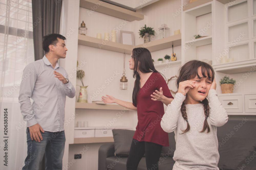Naklejka premium The concept of parental family quarrels, Young Couple Parents are fighting in front of children. The children are very sad to the parents quarrel. Children are crying and headaches.