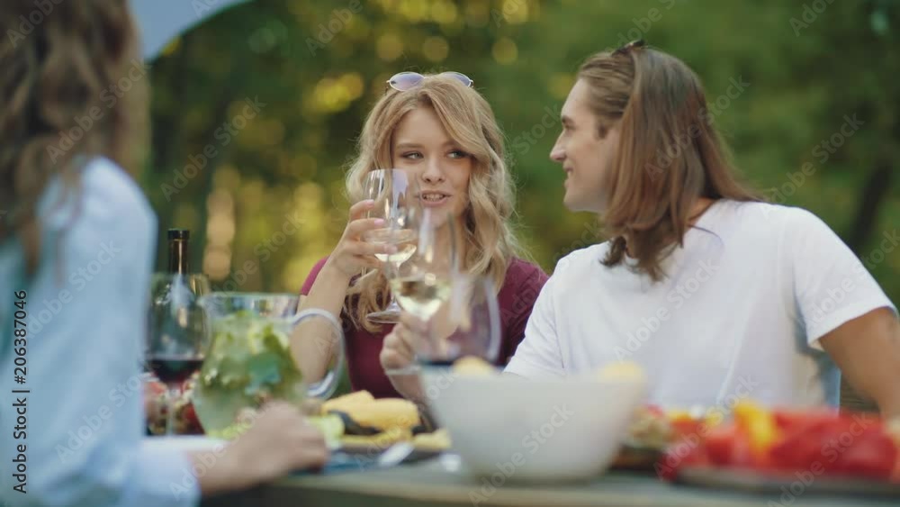 People Cheering With Drinks At Outdoor Dinner Party People Cheering With Drinks At Outdoor Dinner Party