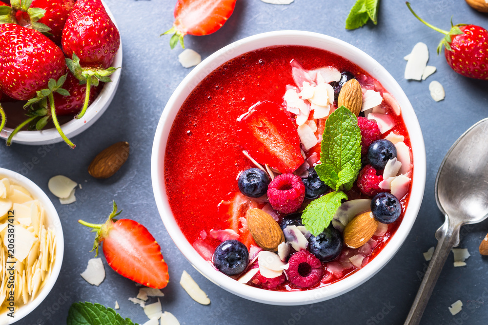 Smoothie bowl from strawberry with fresh berries and nuts. 