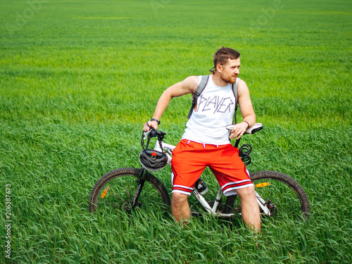 Cyclist on a background of green grass in a field photo