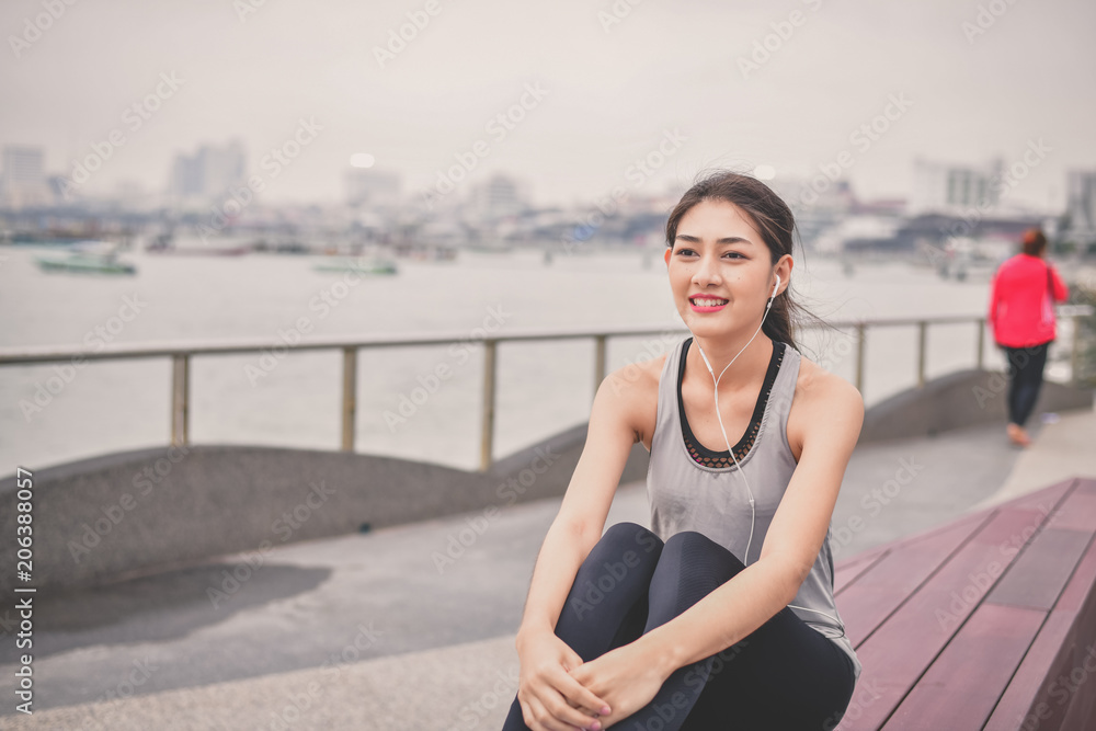 Fototapeta premium Sports concept. Beautiful girl is exercising on the beach with warm up. Beautiful girl is happy to exercise.