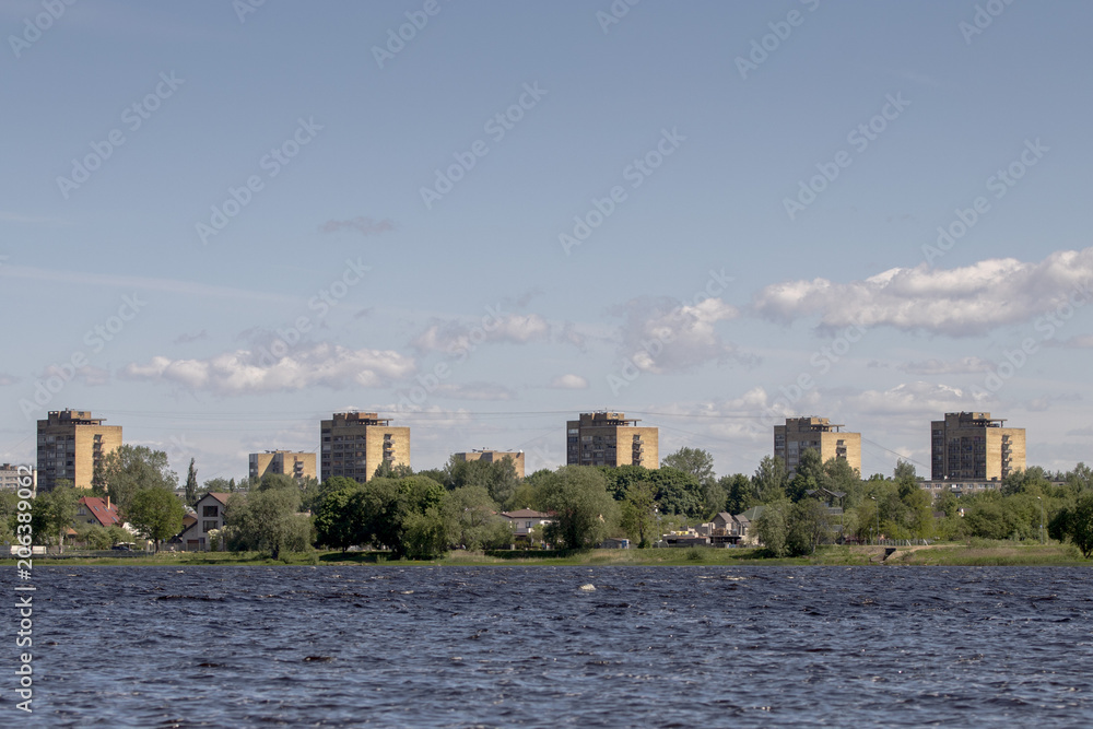 Fototapeta premium old skyscrapers close to river. Old style buildings under blue sky