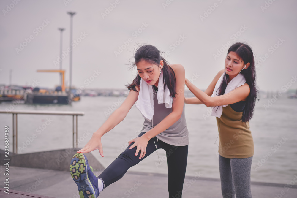 Fototapeta premium Sports concept. Beautiful girl is exercising on the beach with warm up. Beautiful girl is happy to exercise.