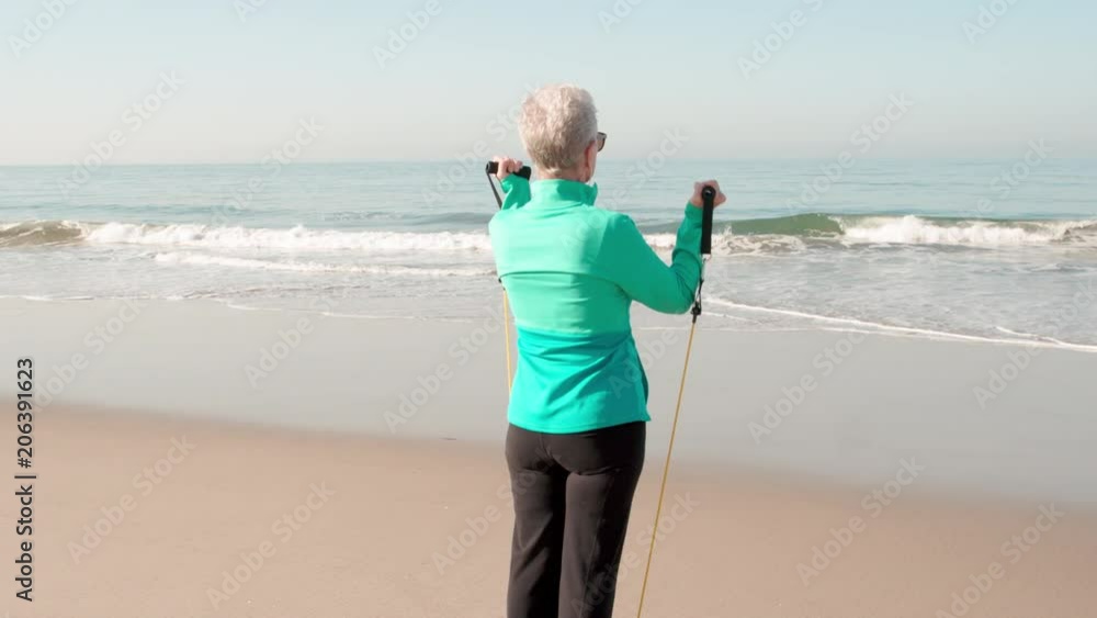 71 year old woman gets her exercise at the beach the beach.