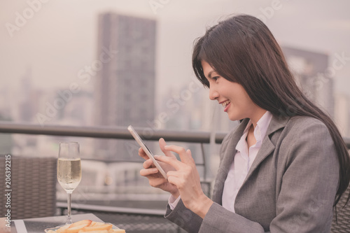 Business Concept. Asian businesswoman looking at mobile phone. Asian businesswoman happy at the top of the building. Beautiful young businesswoman Asians are happily playing mobile. photo