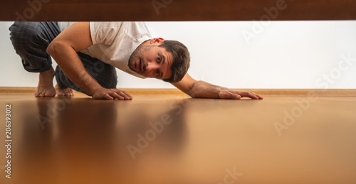 The fellow looking under the bed photo