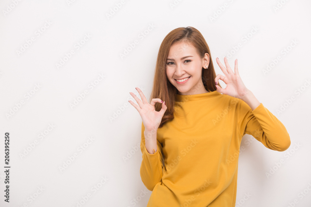 Happy young woman showing ok sign with fingers isolated on a white background Happy young woman showing ok sign with fingers isolated on a white background