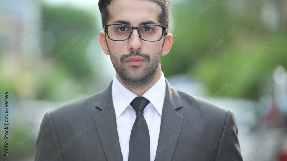 Young handsome bearded Persian businessman in the streets outdoors Young handsome bearded Persian businessman in the streets outdoors