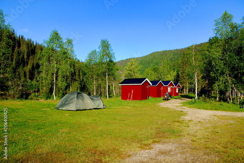 Camping with a tent and houses in the spring forest
