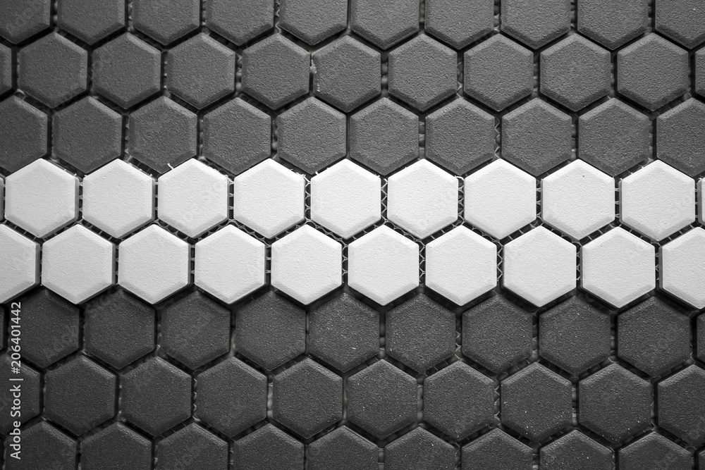 Ceramic tiles mosaic made of gray rhombuses with a white stripe in the middle, without grouting, the mesh-base and glue is visible. The concept of repair. Background. Ceramic tiles mosaic made of gray rhombuses with a white stripe in the middle, without grouting, the mesh-base and glue is visible. The concept of repair. Background.