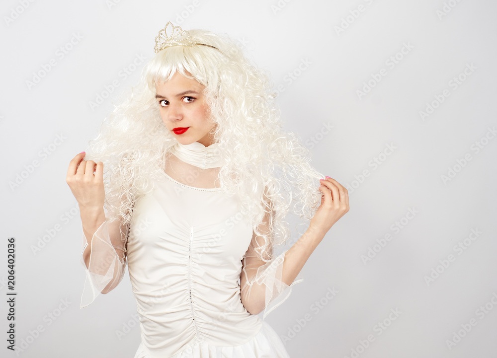 Confident and flirtatious young woman with tiara on light background Confident and flirtatious young woman with tiara on light background