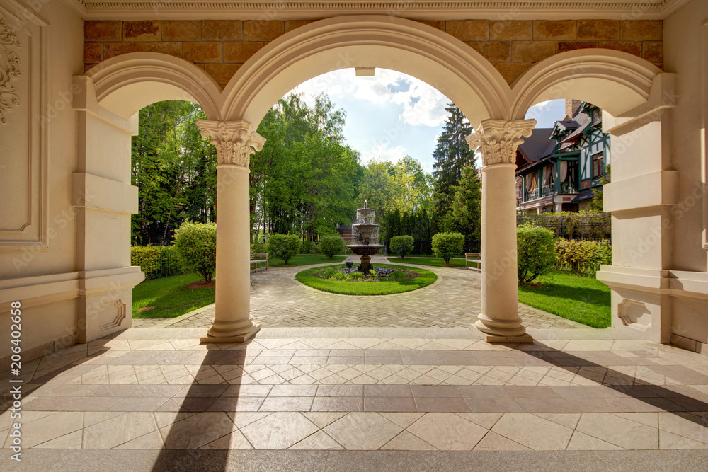An arch with an exit to a lawn with the fountain
An arch with an exit to a lawn with the fountain