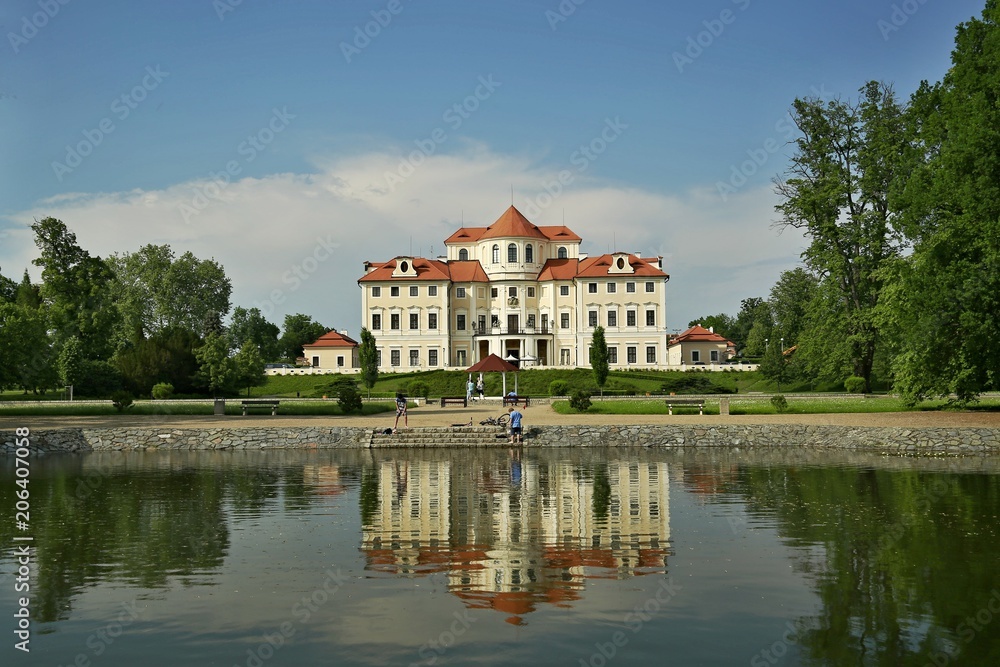 Liblice, Czech Republic / Europe - May Day Year: Reflection of castle Liblice close to Melnik in water built in baroque style with garden, gazebo,lake, green grass, trees, on a sunny day with blue sky