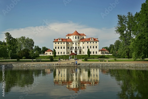 Liblice, Czech Republic / Europe - May Day Year: Reflection of castle Liblice close to Melnik in water built in baroque style with garden, gazebo,lake, green grass, trees, on a sunny day with blue sky