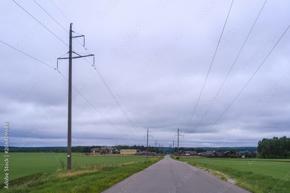 Fototapeta premium Field, the cloudy sky and country road