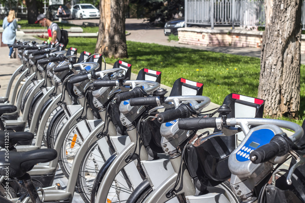 A number of city bikes in gray in automatic rental