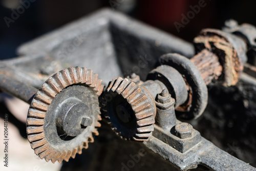 Old metal gears in drive mechanisms. Rusty gears used in machines from the last century.