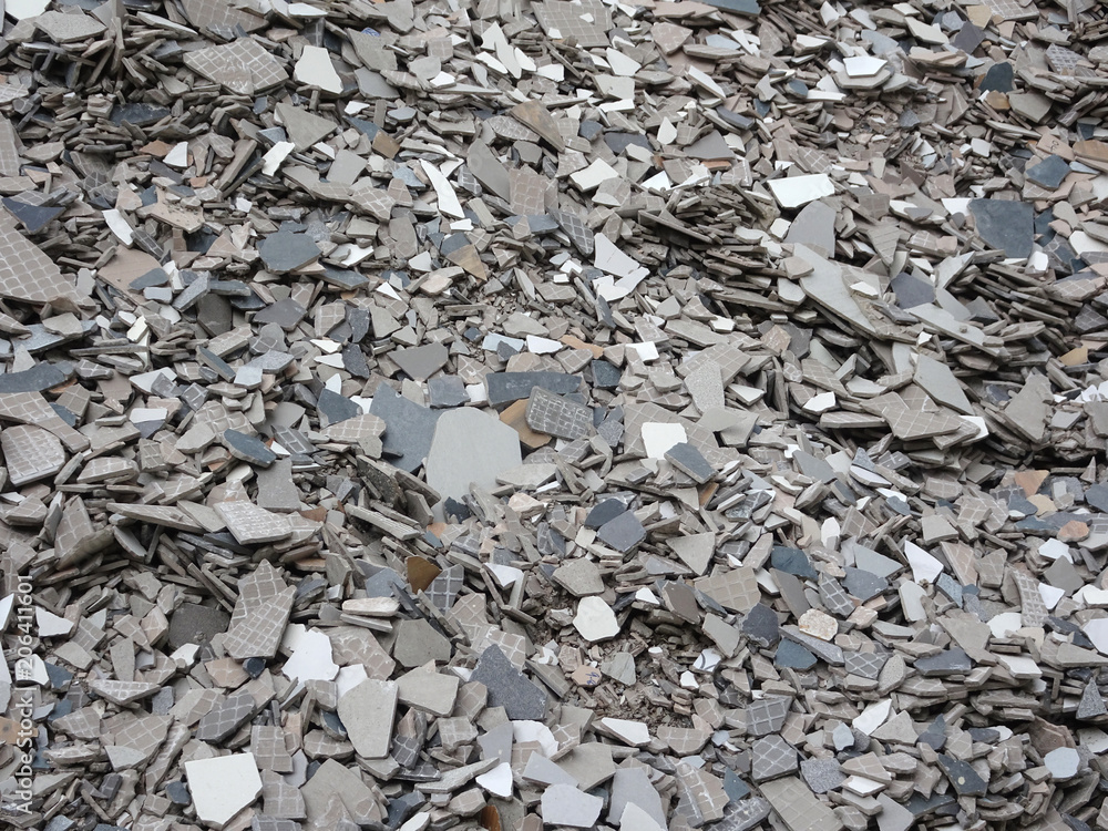 Broken homogeneous and ceramic floor tiles. Broken tiles are collected