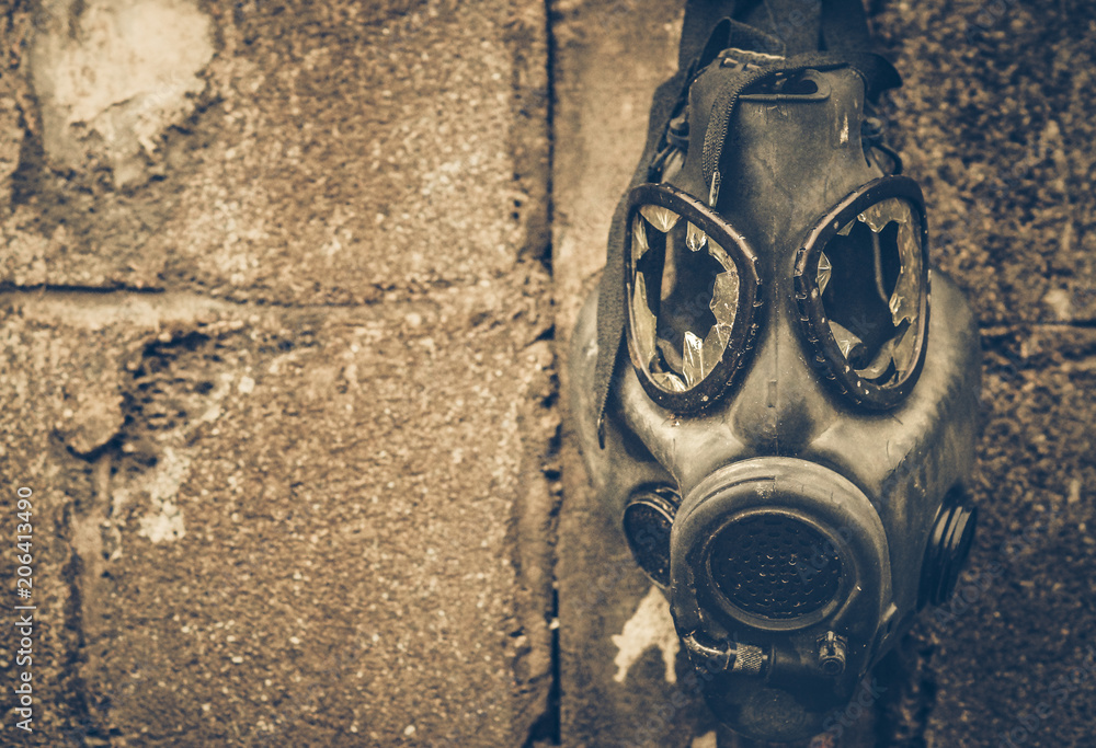 Broken gas mask hung on the wall / Toxic chemical weapon concept Stock