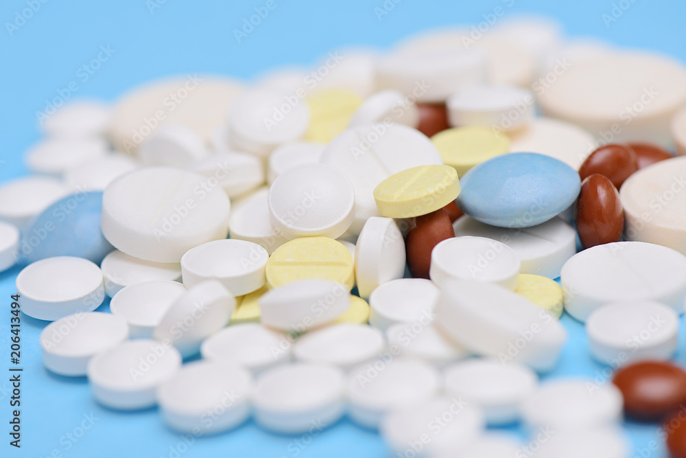 different medicine pills and tablets on blue background different medicine pills and tablets on blue background